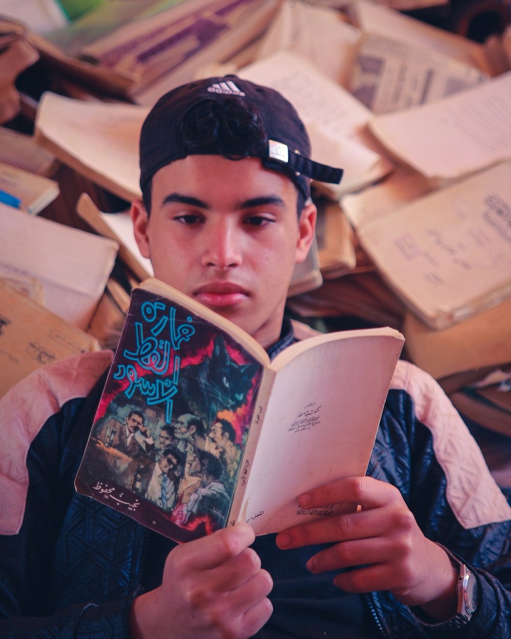 man in blue long sleeve shirt holding book