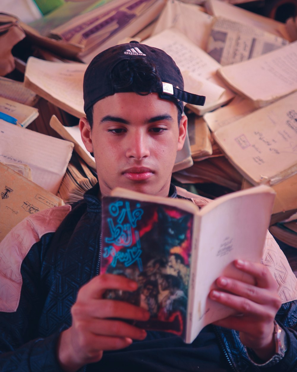 man in black jacket holding book