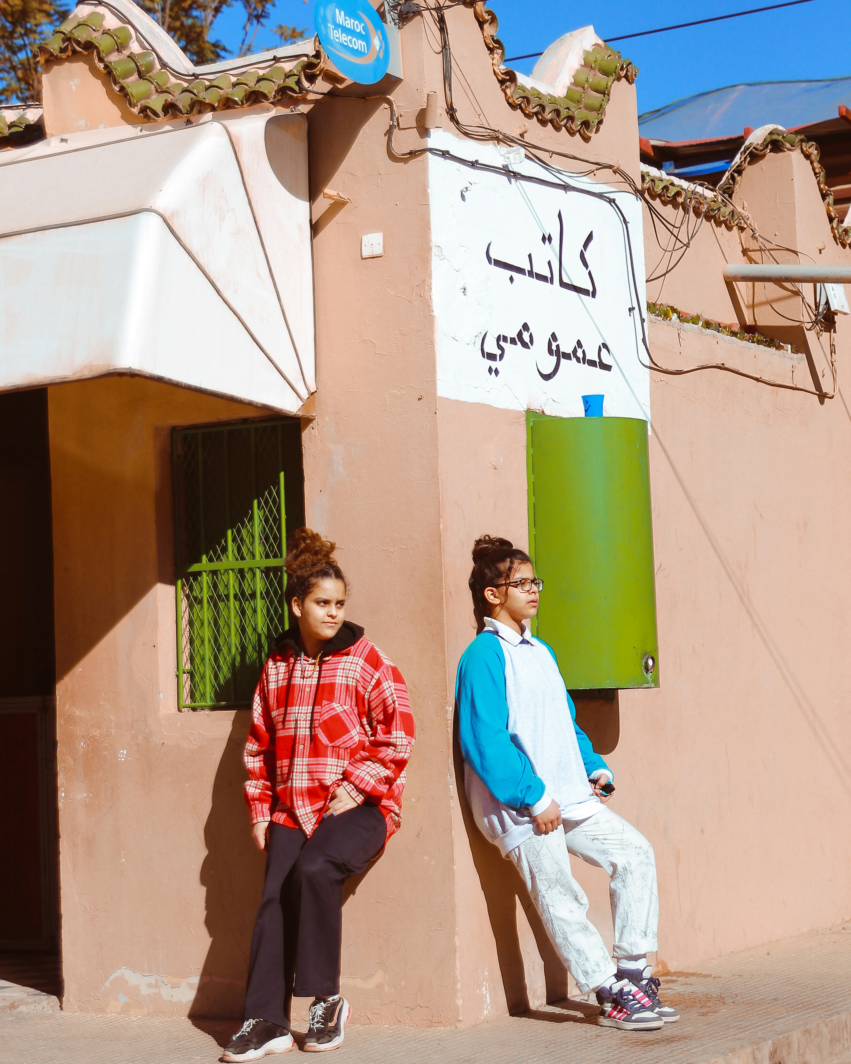 man in red and white long sleeve shirt and black pants standing beside green and white