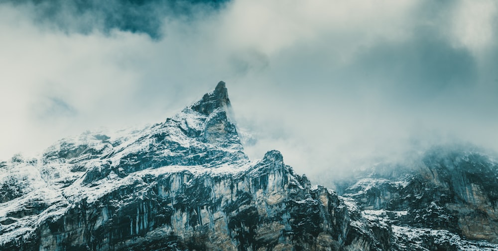 snow covered mountain under cloudy sky during daytime