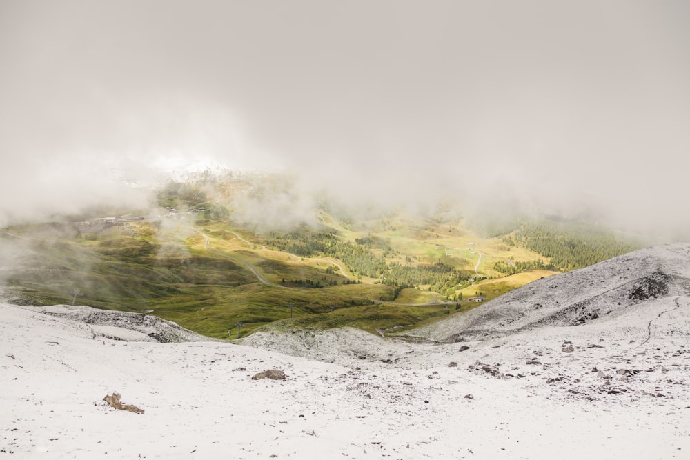 green grass covered mountain under white clouds during daytime