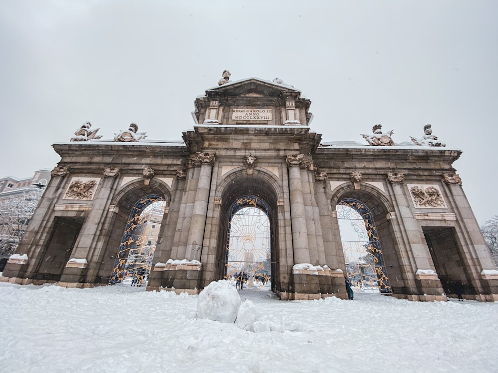 people walking on snow covered ground near white concrete building during daytime