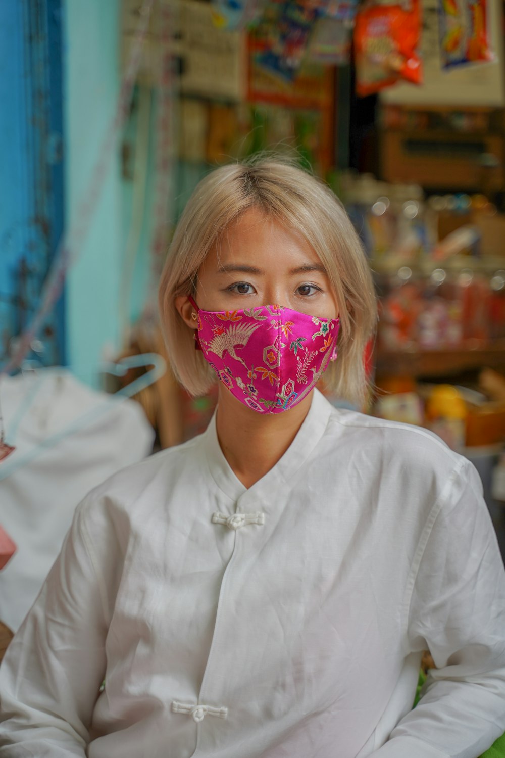 girl in white button up shirt with pink and white floral mask