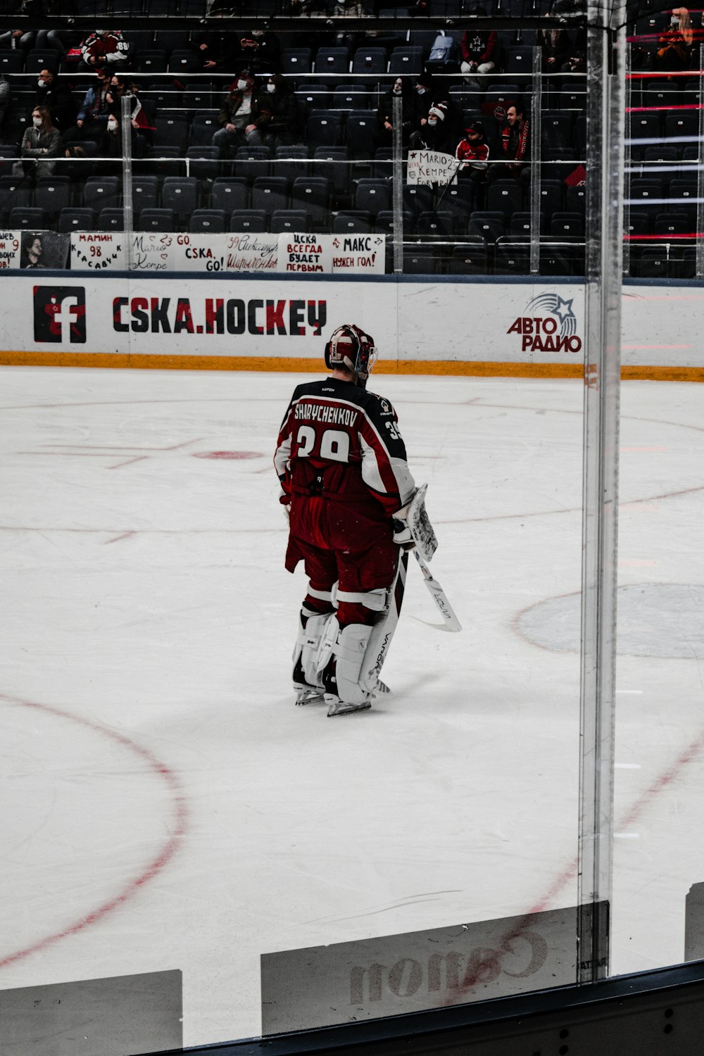 man in black and red ice hockey jersey playing hockey