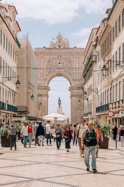 people walking on street near white concrete building during daytime
