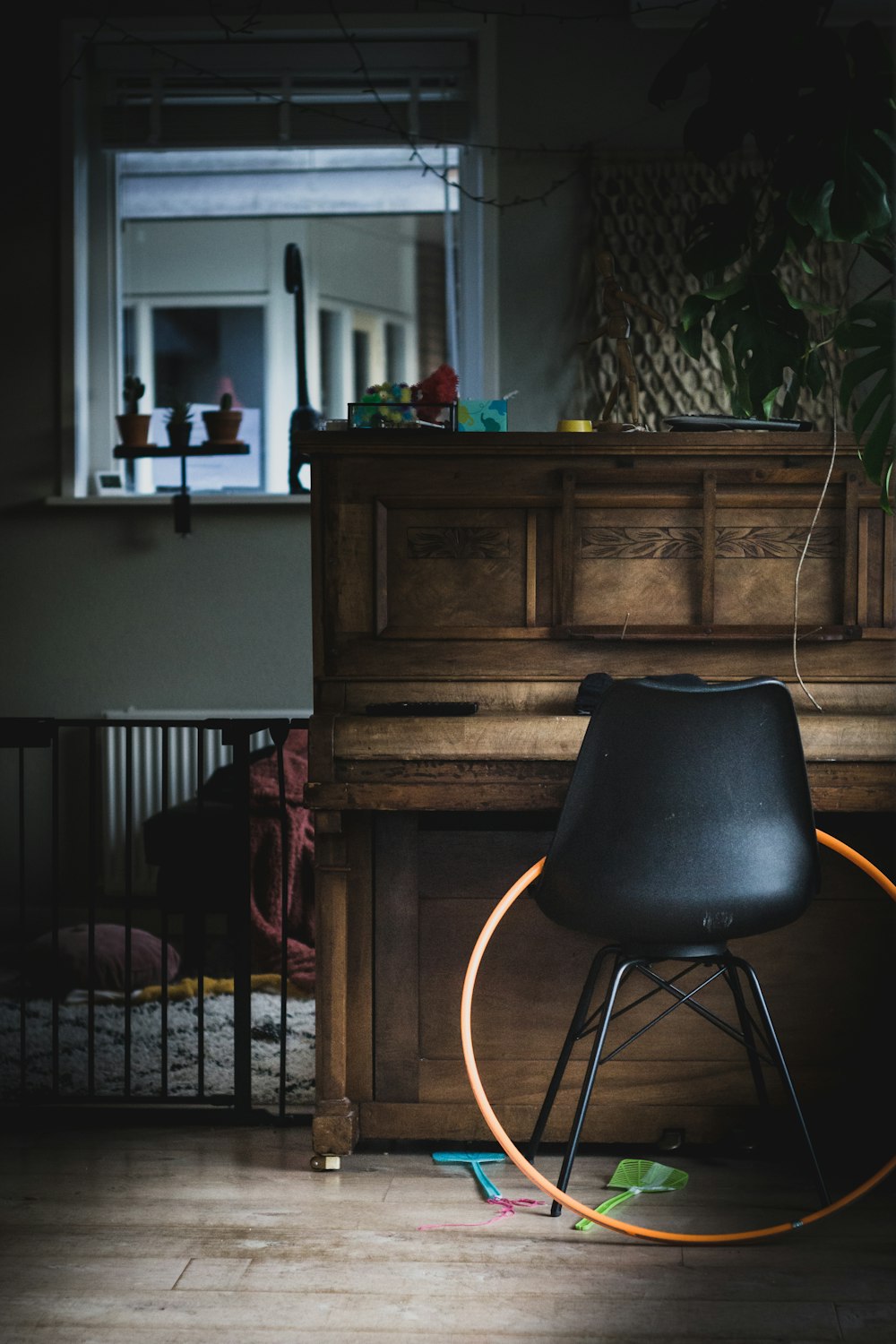 black leather chair beside brown wooden upright piano