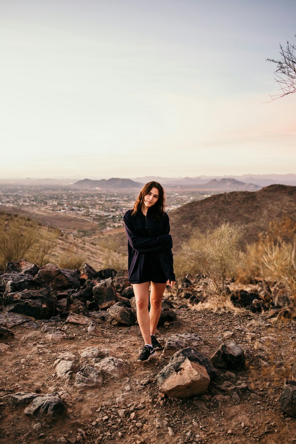 woman in black long sleeve dress standing on rocky ground during daytime