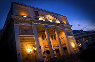 Institutional building lit up at dusk, showcasing electrical work.