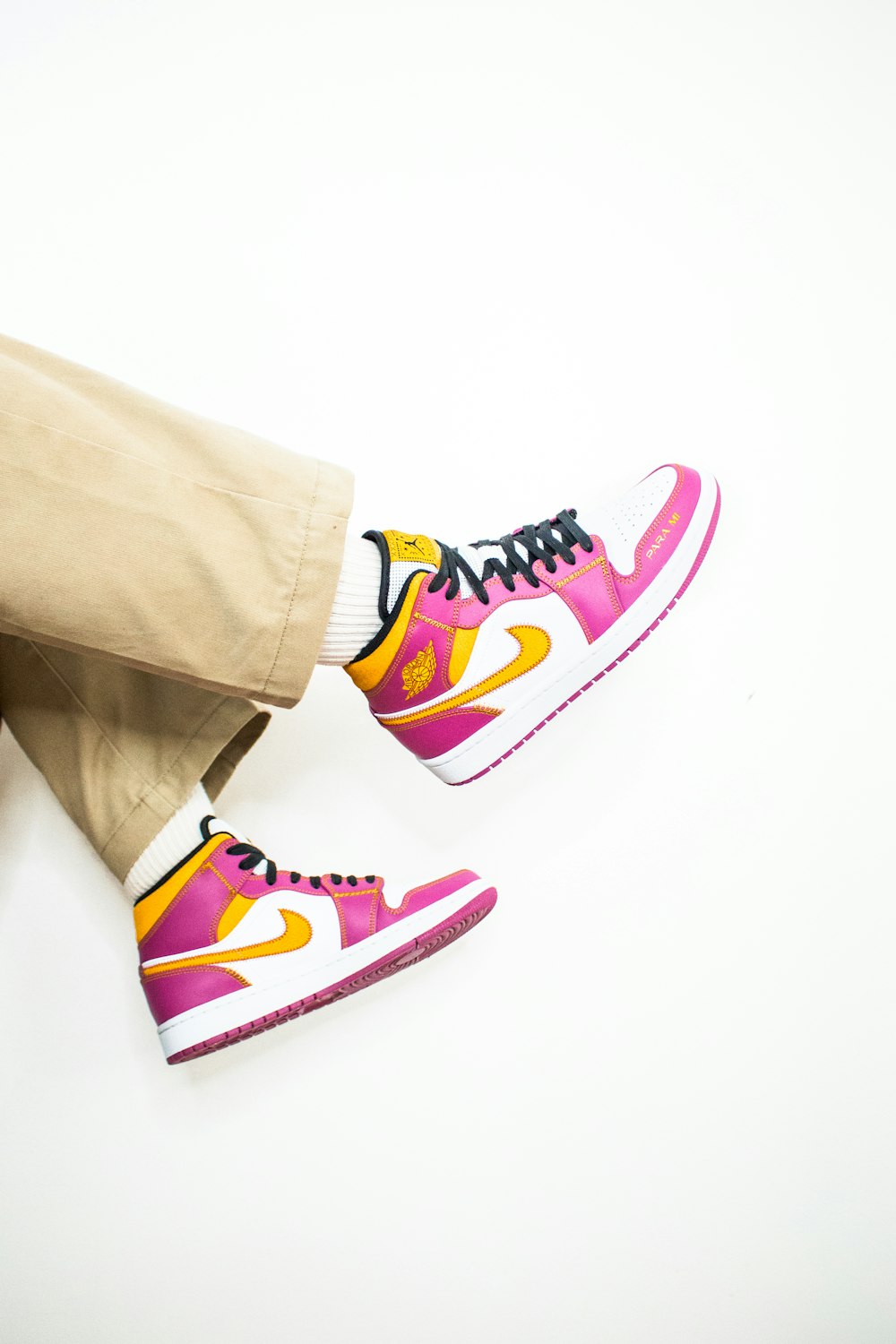 person in brown pants and blue white and pink nike sneakers