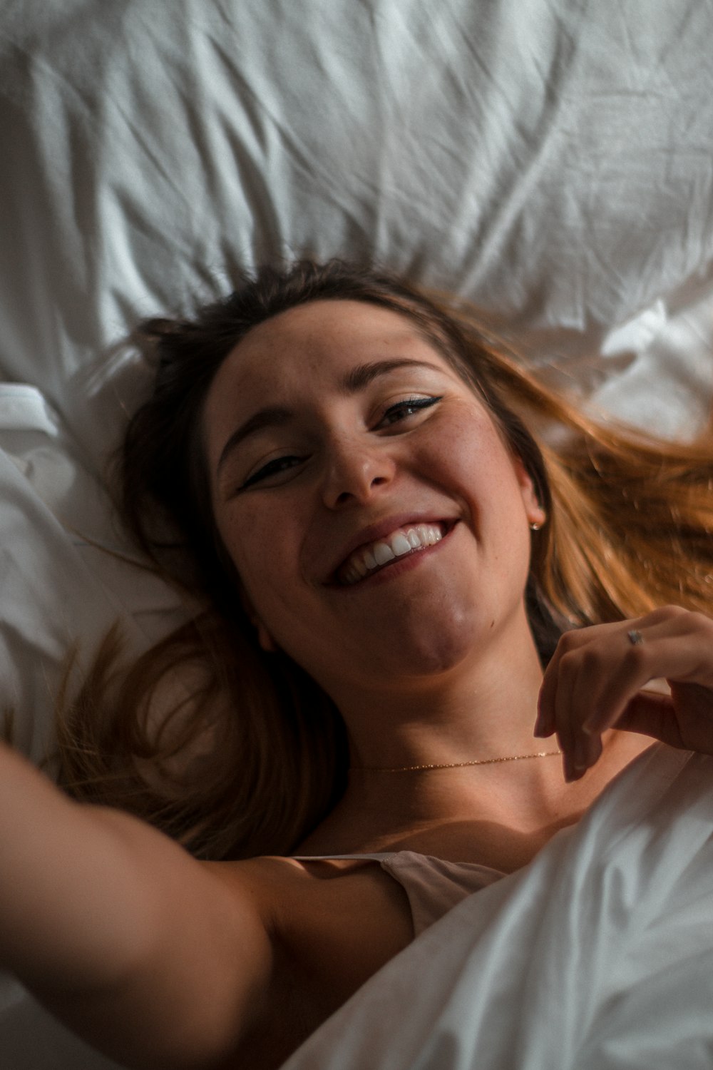 woman lying on white textile