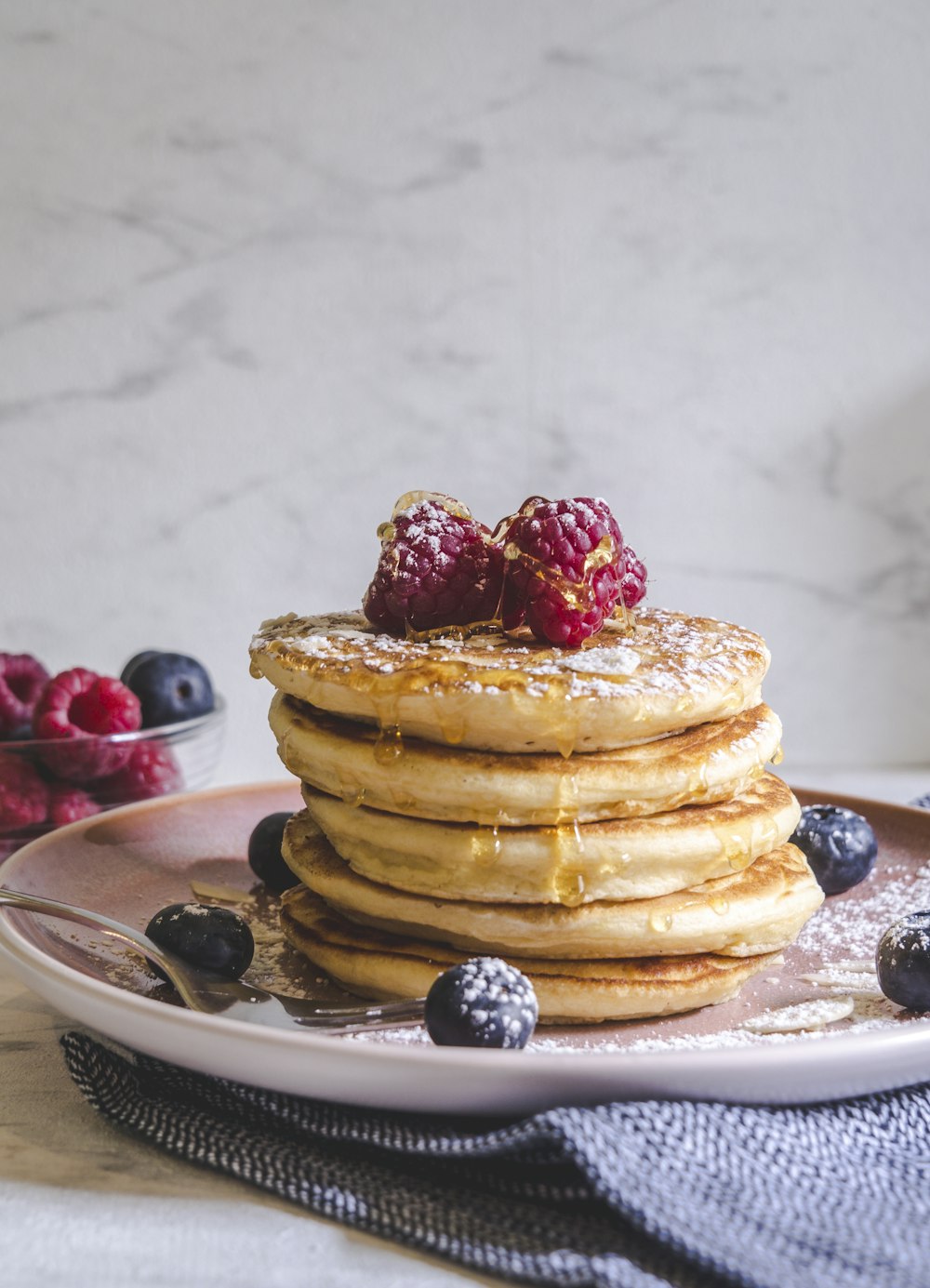 Crêpes aux fruits rouges sur assiette en céramique blanche