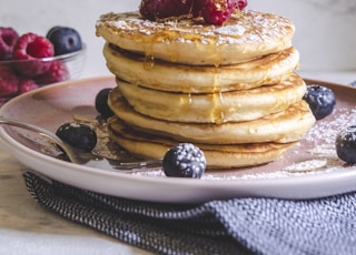 pancakes with berries on white ceramic plate