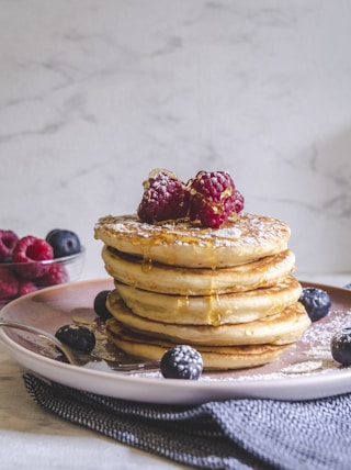 pancakes with berries on white ceramic plate