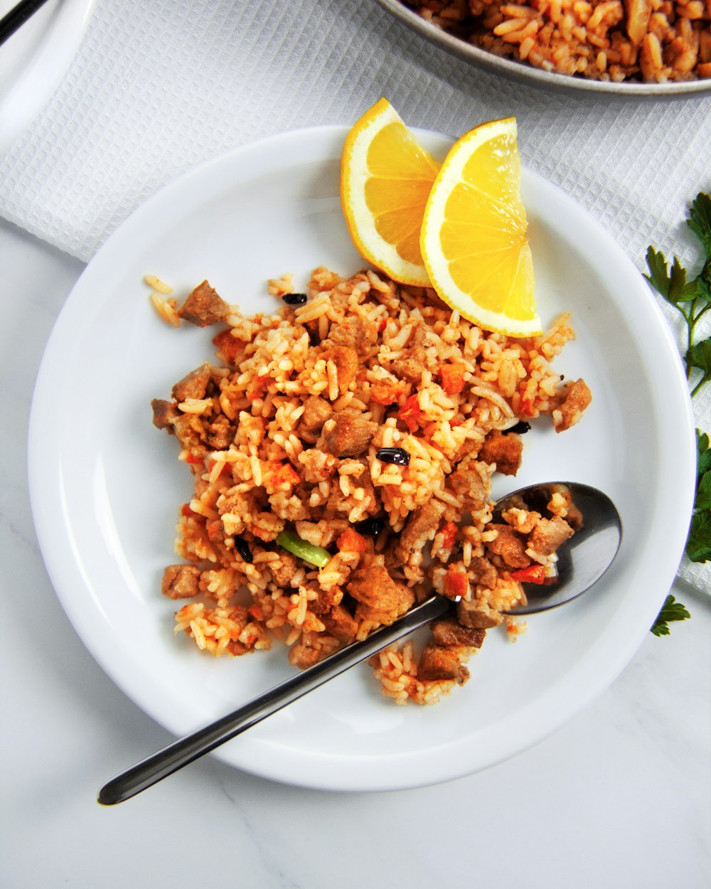 fried rice with sliced lemon on white ceramic plate