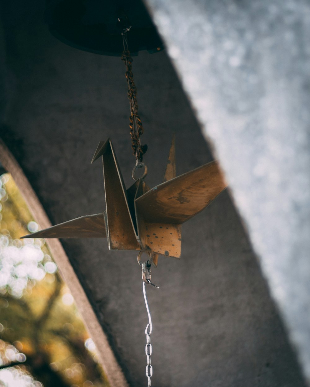 brown wooden wind chime on gray concrete wall