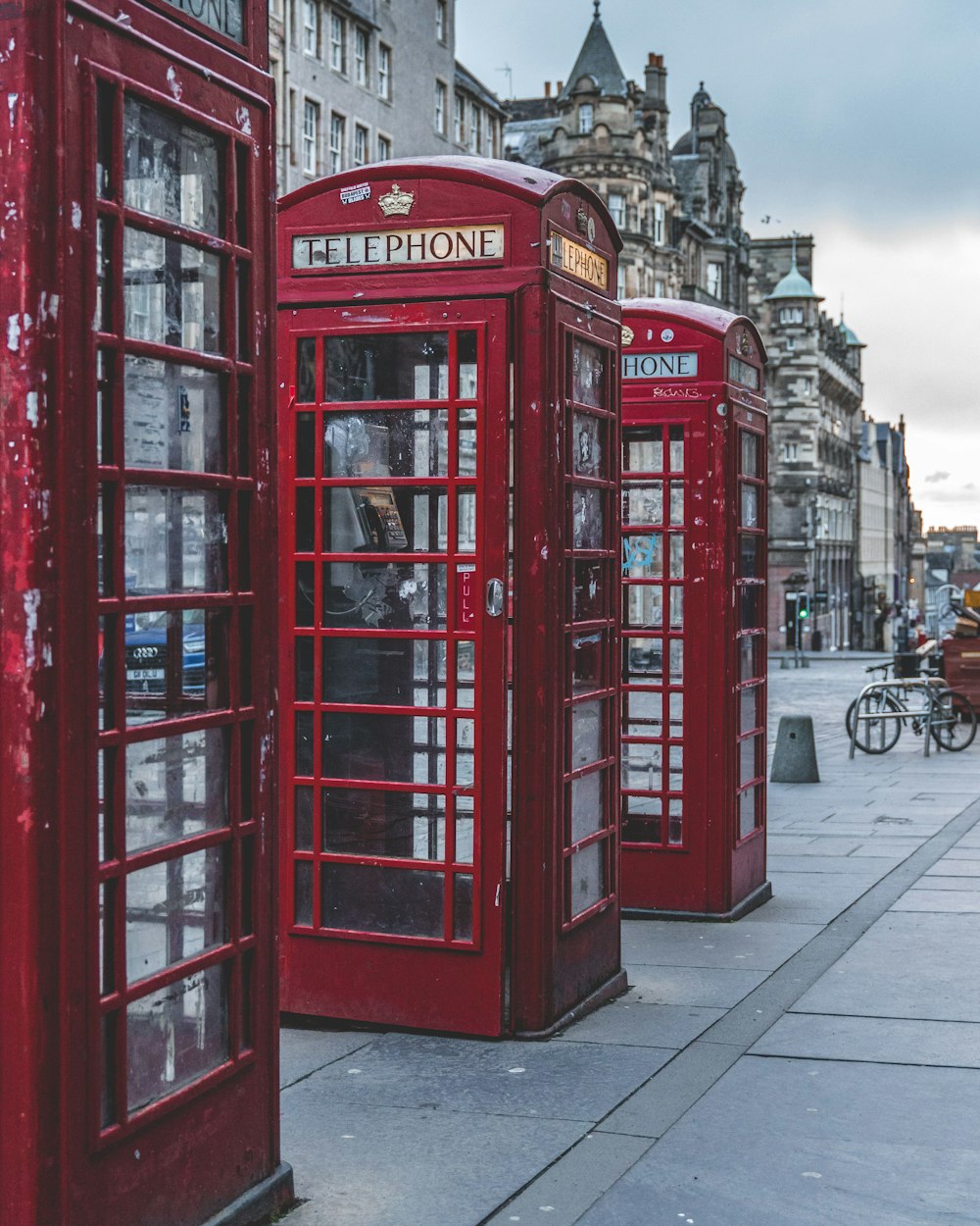 red telephone booth near gray concrete building during daytime