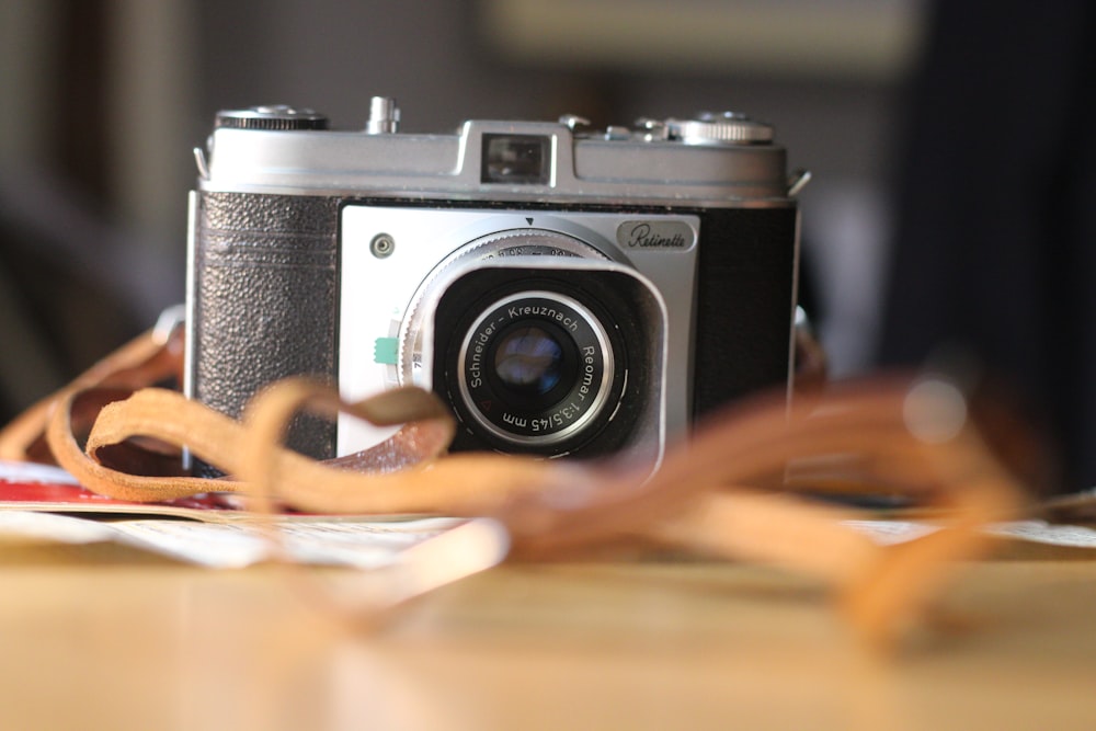 black and silver dslr camera on brown wooden table