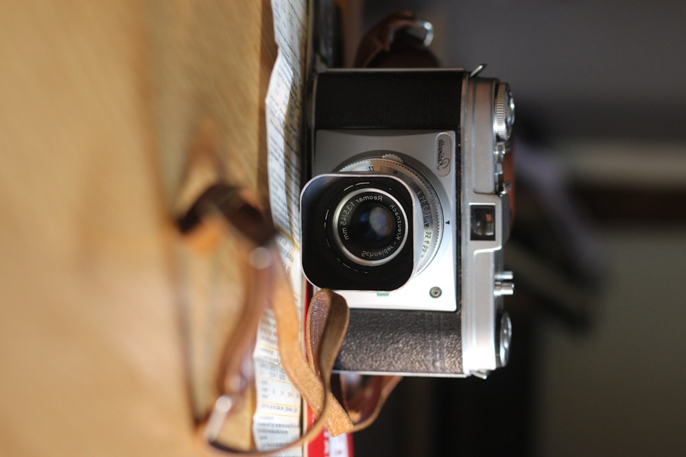 black and silver camera on brown wooden table