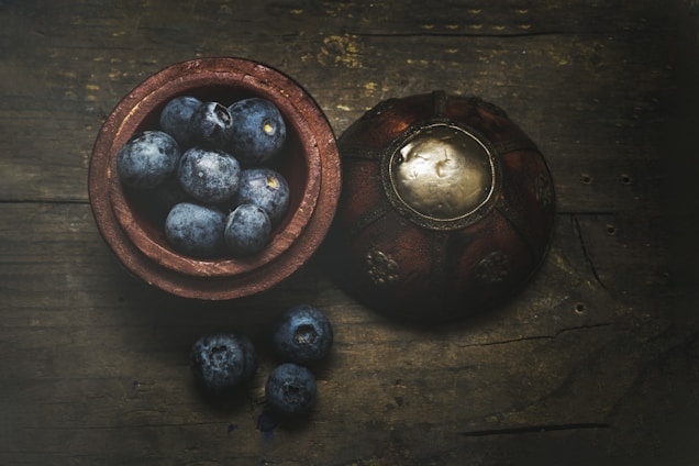 A close-up of fresh, organic blueberries on a wooden table.