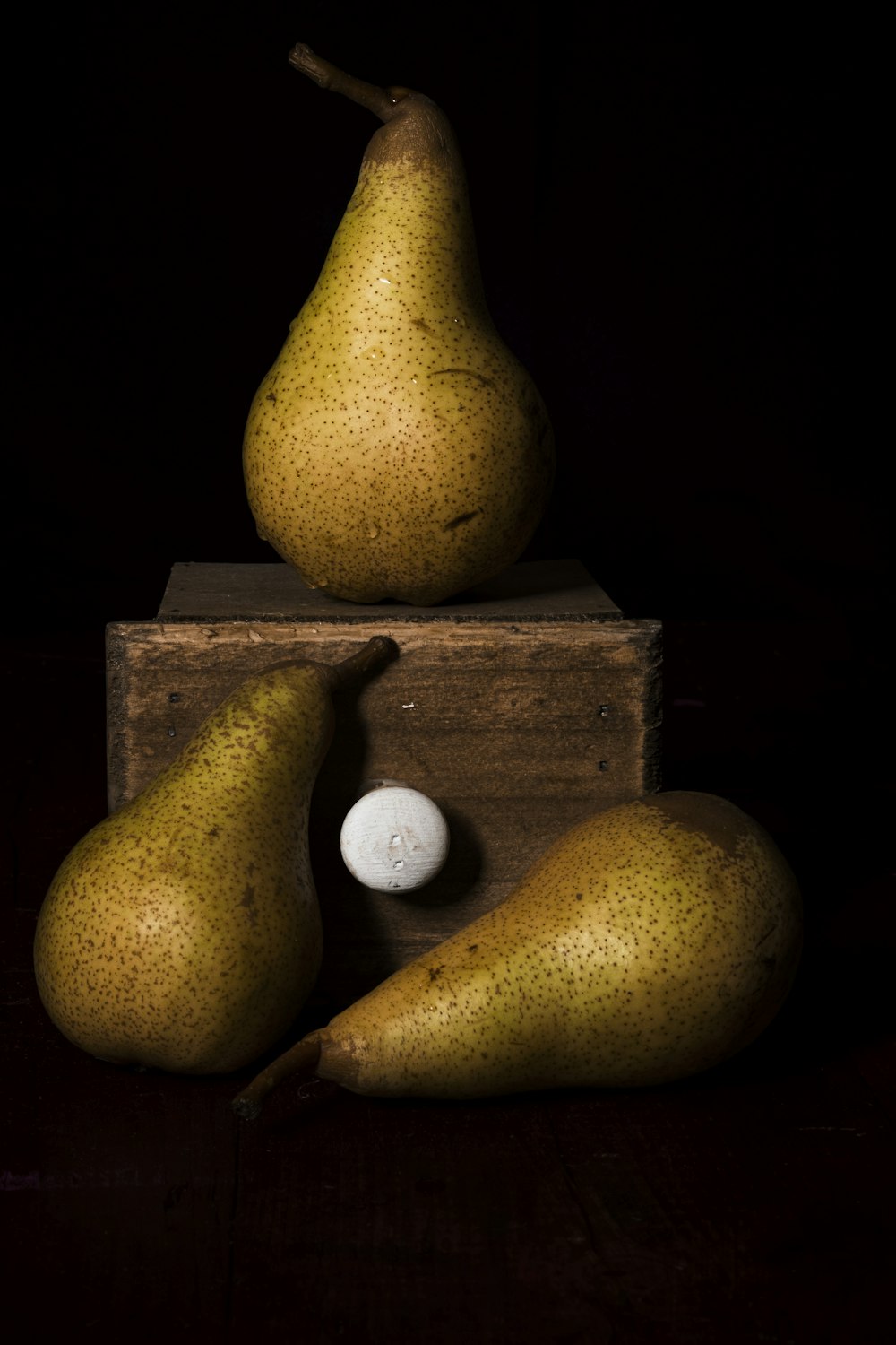 two yellow and white oval fruits on brown wooden box