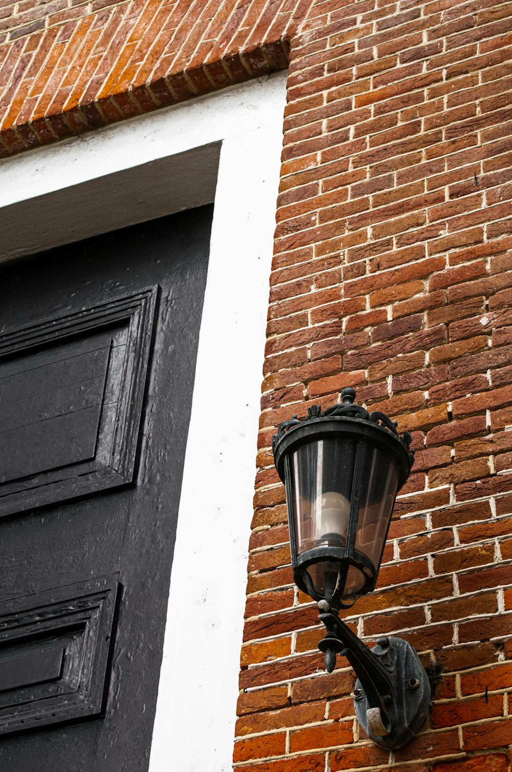 black sconce lamp on brown brick wall
