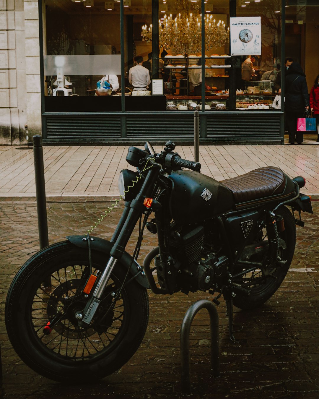 black motorcycle parked near white building during daytime