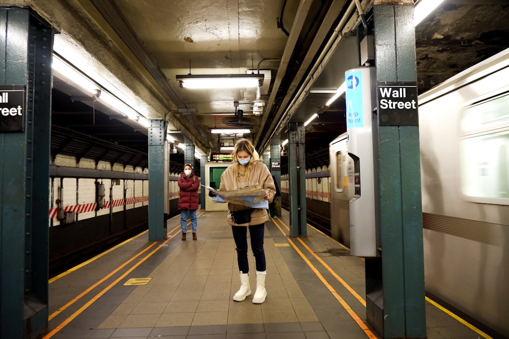 기차역에 서 있는 갈색 코트를 입은 여자