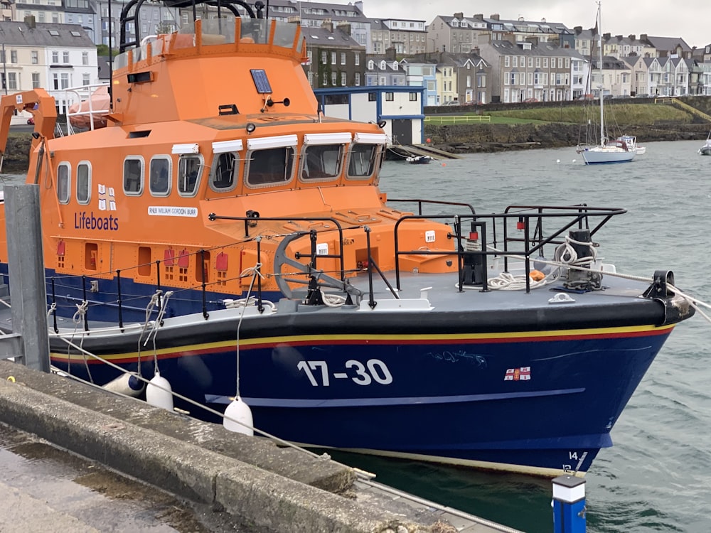 blue and orange boat on dock during daytime