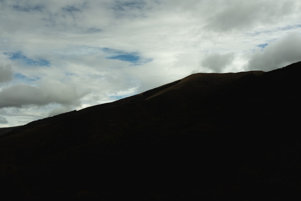 white clouds over green mountain