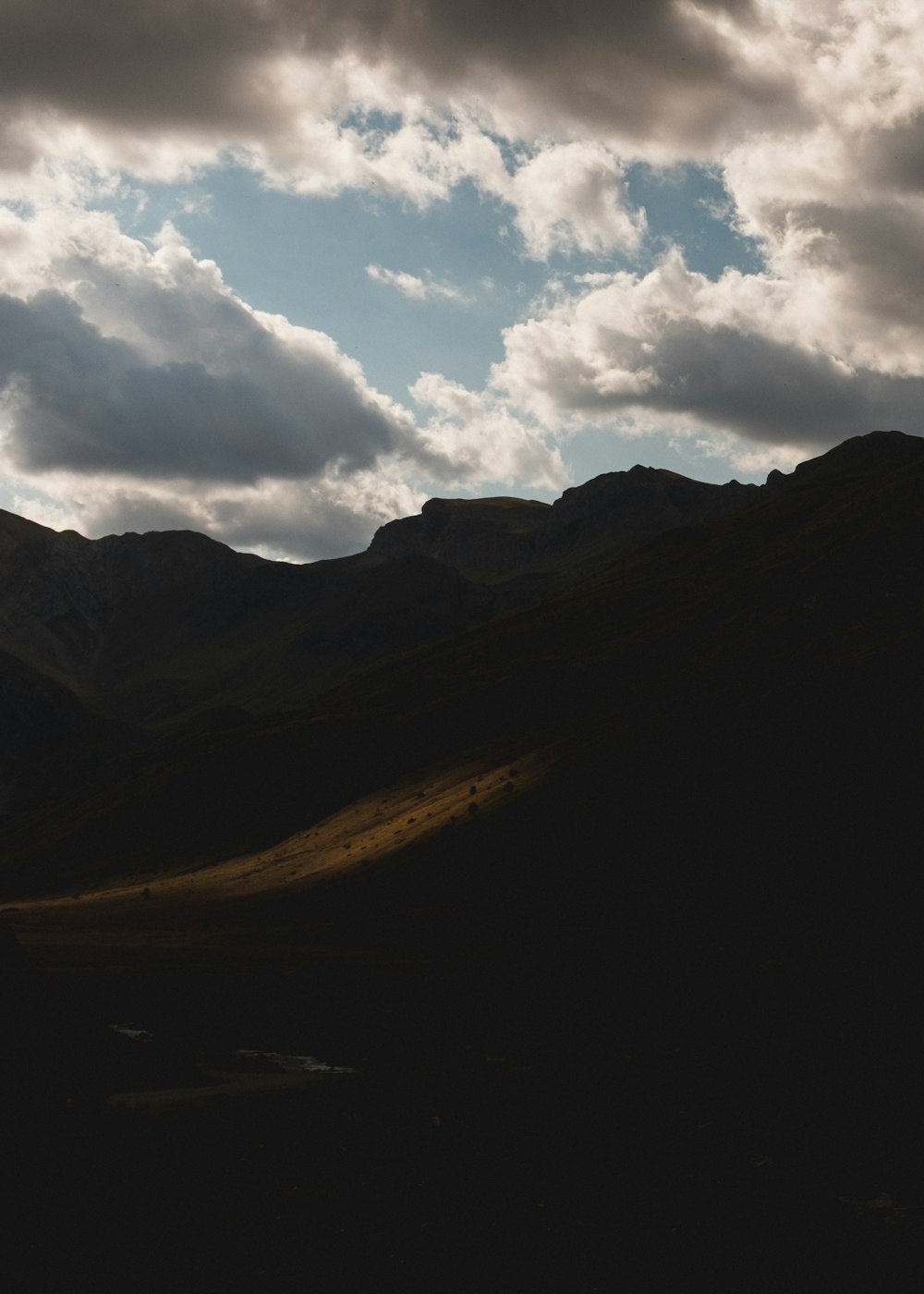 brown mountain under white clouds during daytime