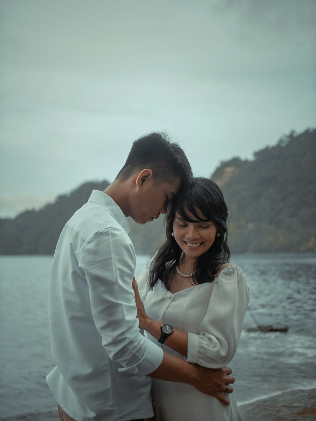 man and woman standing near body of water during daytime