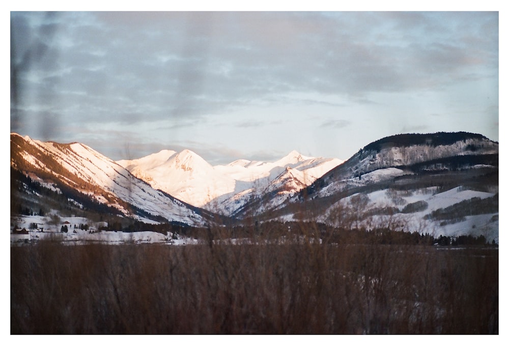 brown and white mountains under white clouds during daytime