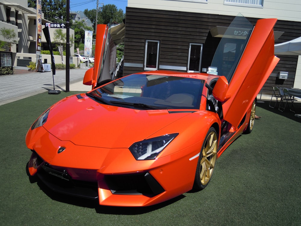 orange ferrari sports car parked near white and brown building during daytime