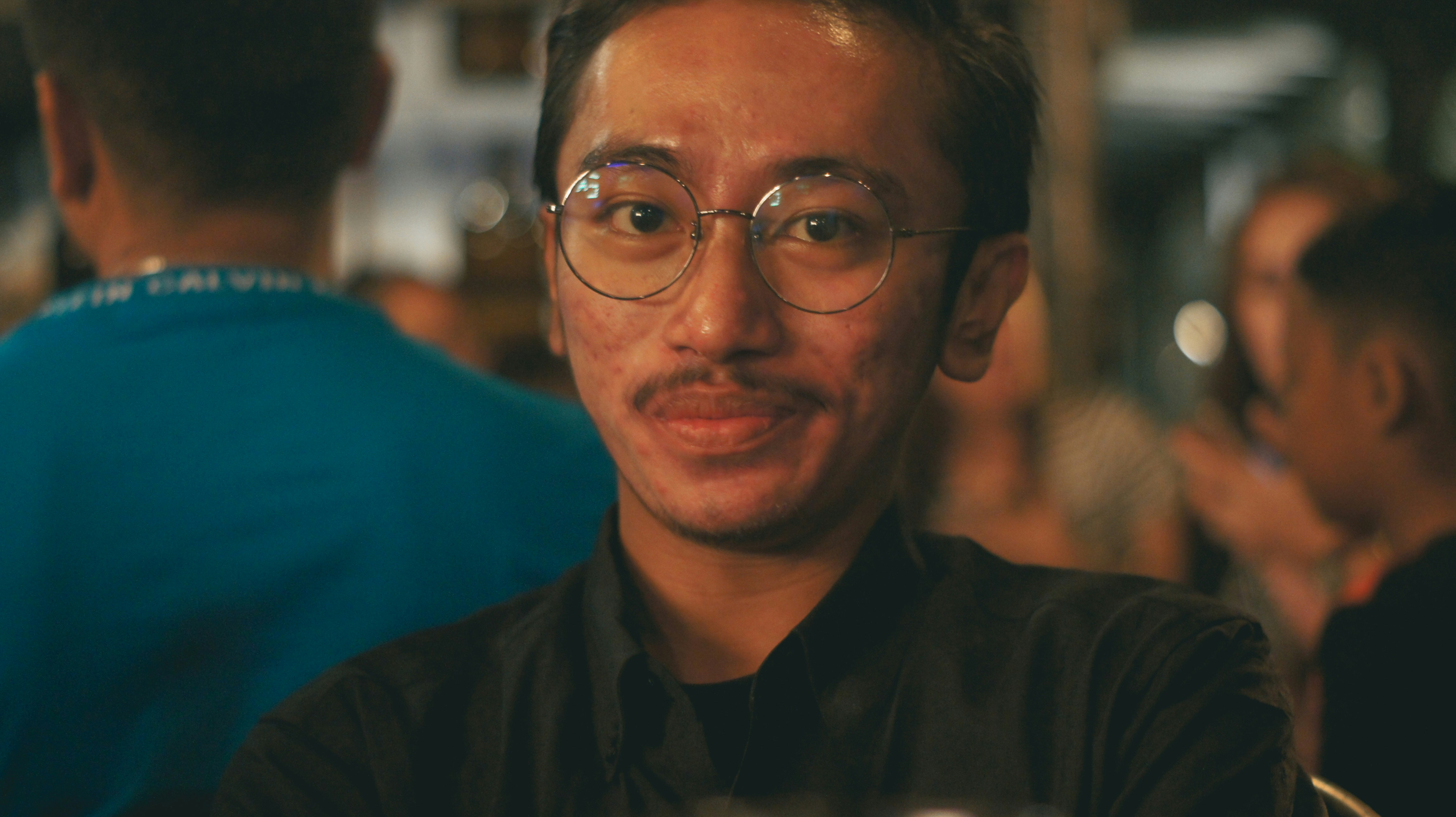 man in black dress shirt wearing black framed eyeglasses