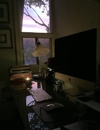 A serene workspace with ancient astrology texts, a laptop, and vastu diagrams illuminated by soft natural light.