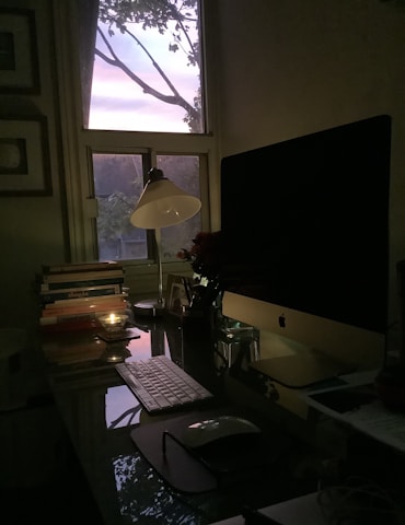 A cozy workspace with a laser engraving machine surrounded by mystical symbols and soft candlelight.