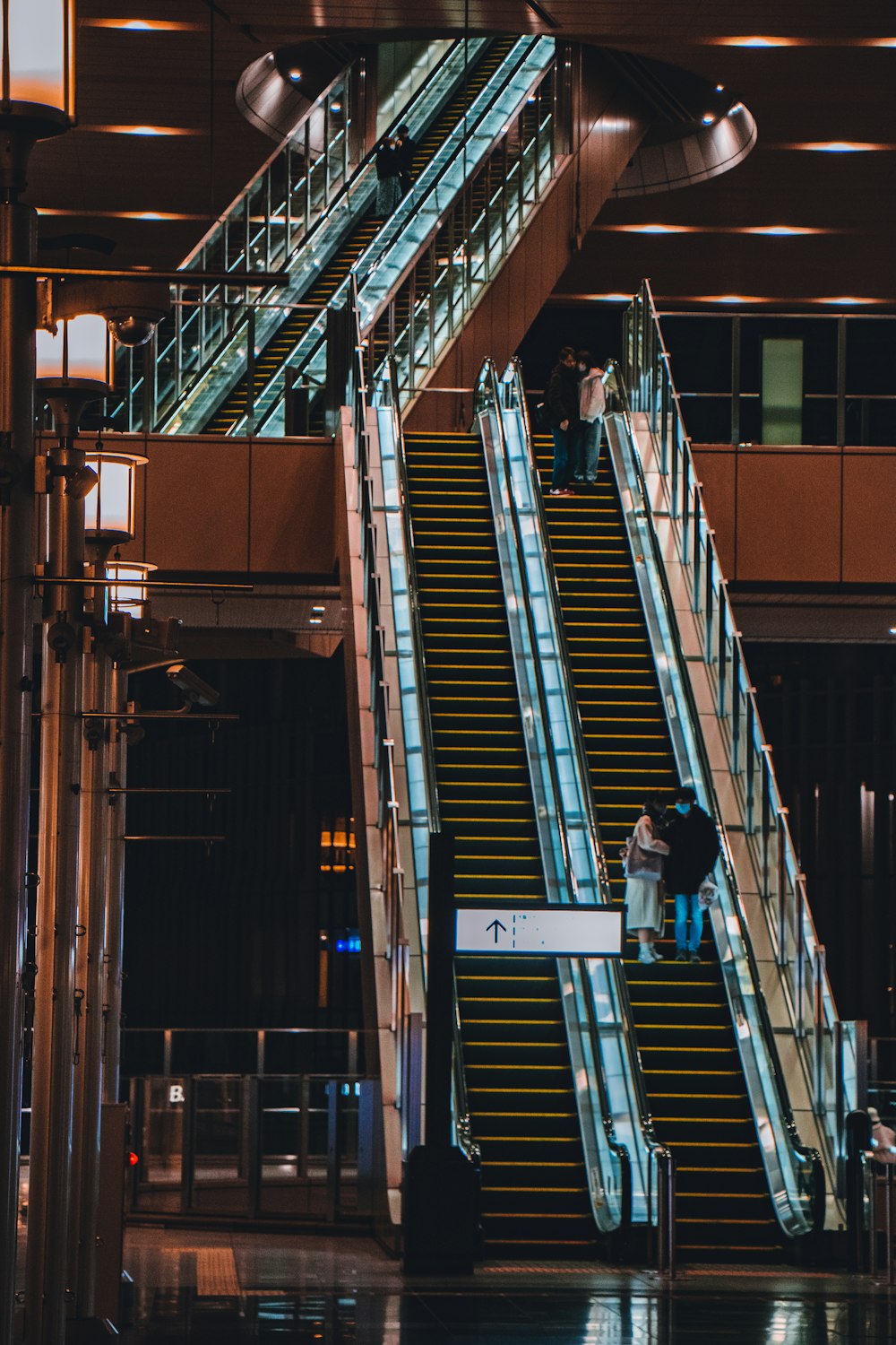 man in black jacket and blue denim jeans standing on the stairs