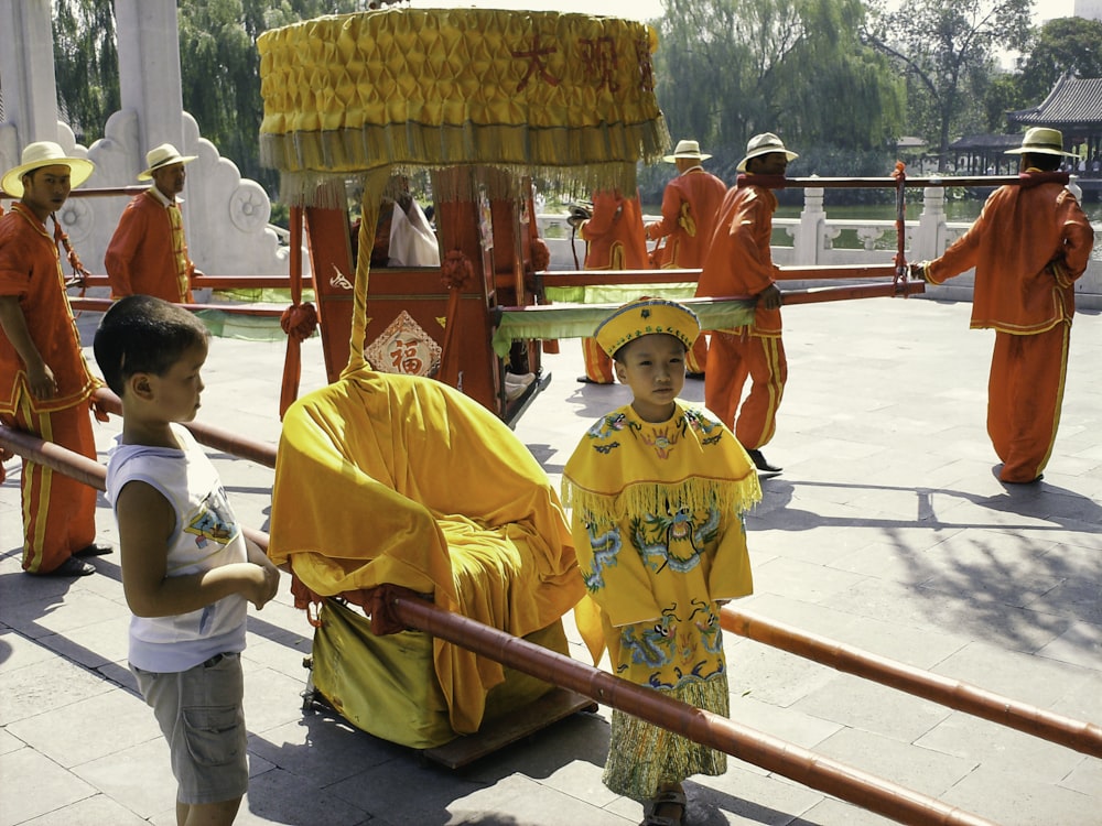 woman in yellow and red traditional dress standing beside red metal railings