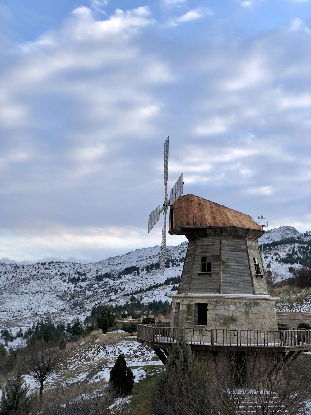 brown and white concrete building near mountain under white clouds during daytime