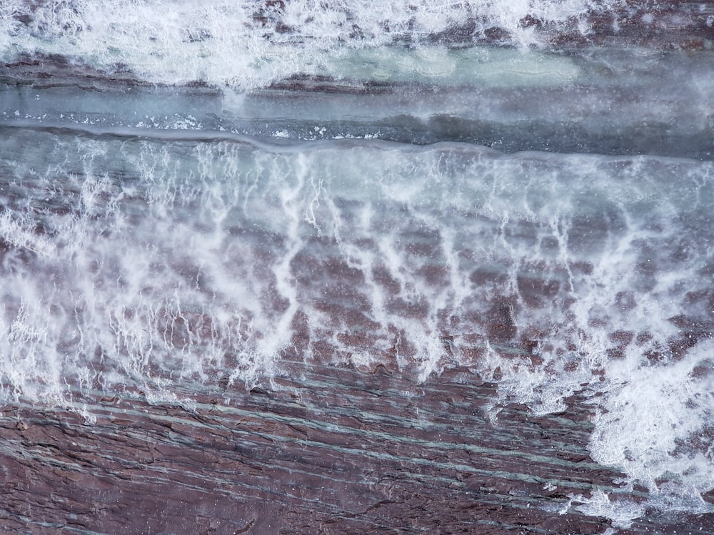 water waves hitting on brown wooden surface