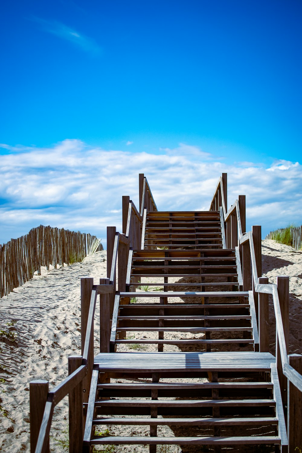 brown wooden stairs on white sand during daytime