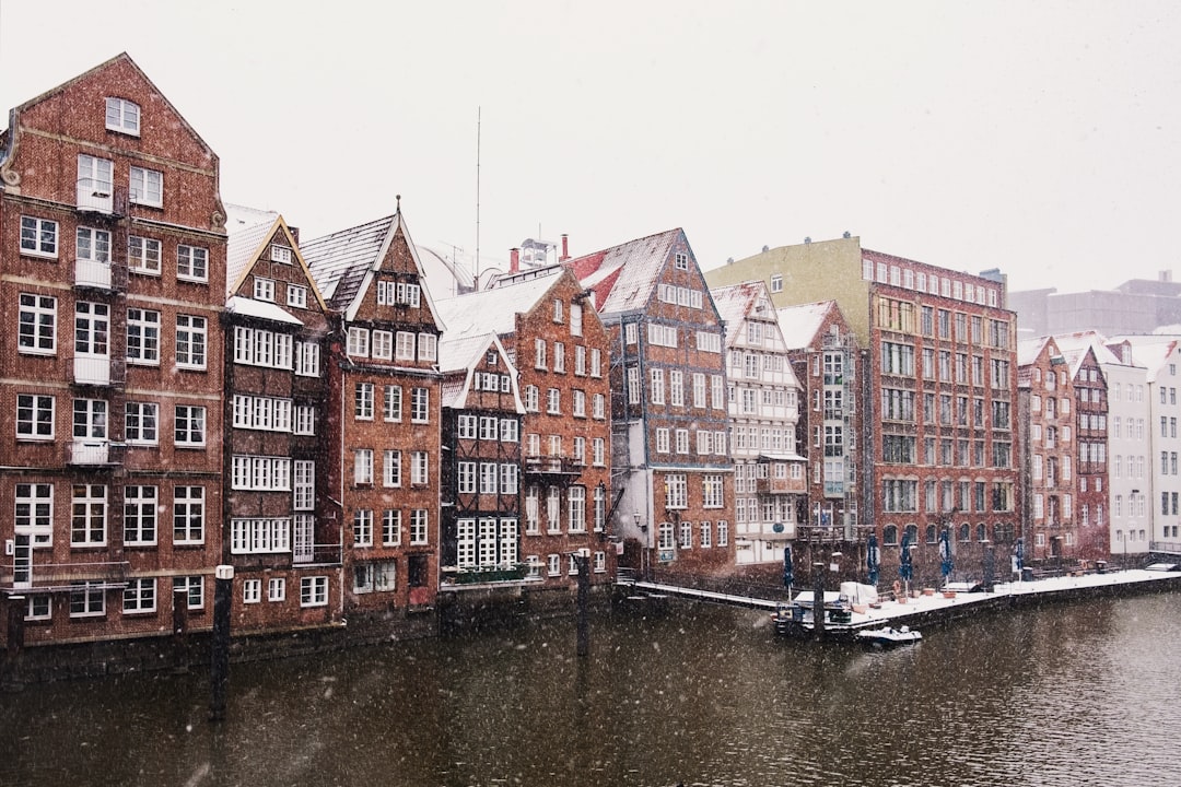 brown and red concrete building beside river during daytime