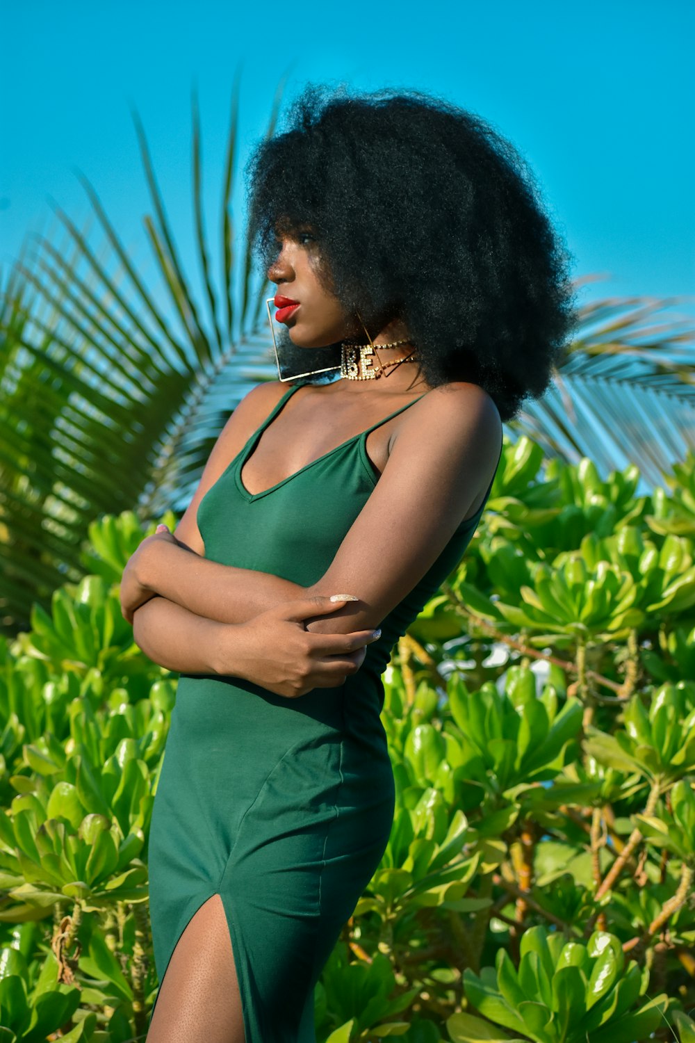 woman in green tank top standing near green plants during daytime