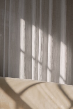 A serene portrait bathed in soft beige light, highlighting natural textures and subtle shadows.