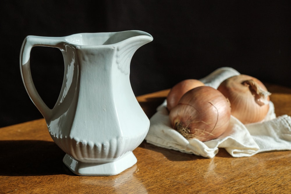 white ceramic vase on brown wooden table