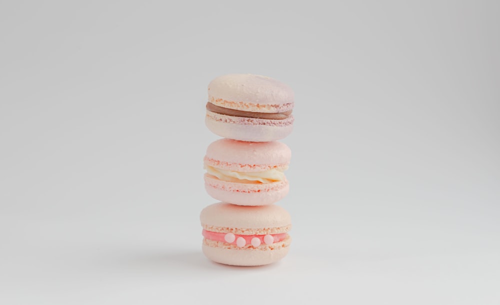 3 white macaroons on white surface