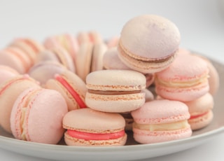 pink and white macaroons on white ceramic bowl