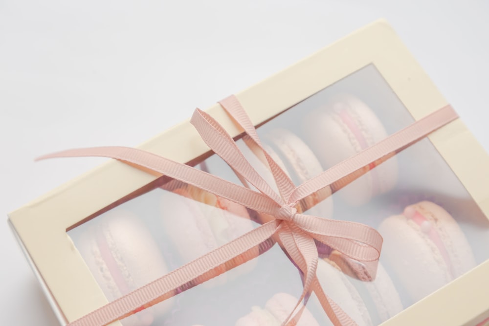 a box of macaroons wrapped in a pink ribbon