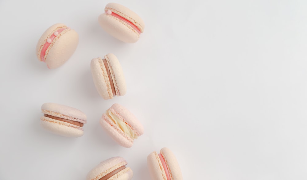 um grupo de macarons sentados em cima de uma mesa branca