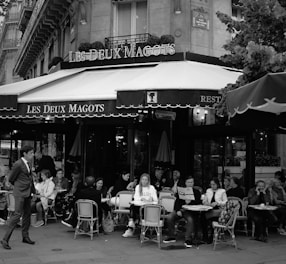 A vibrant crowd engaging in lively discussion within an intimate Parisian cinema setting.